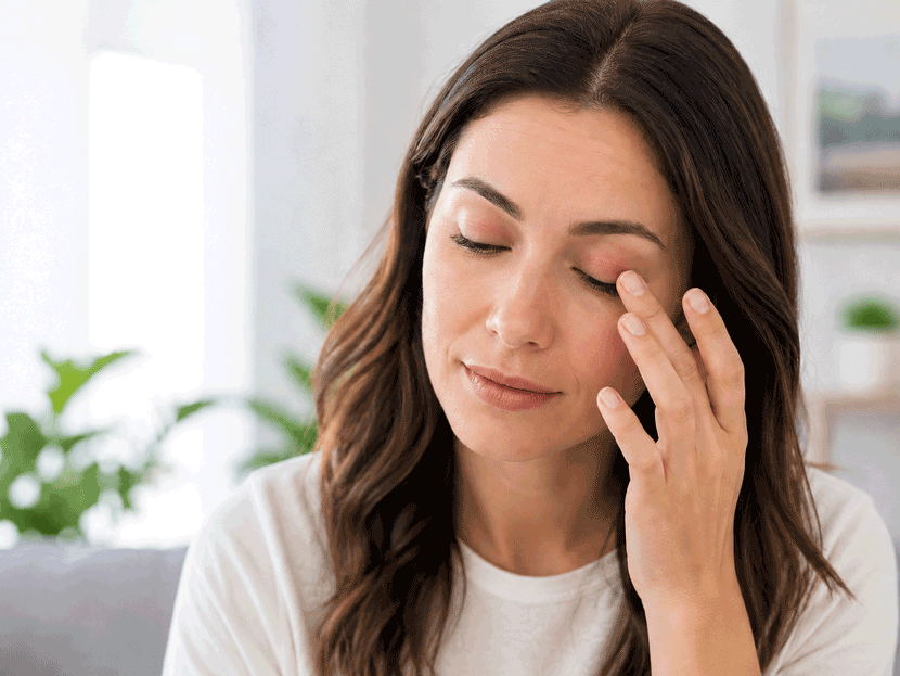 Aiello Eye Institute featured image of an adult woman gently touching a mildly irritated eyelid to illustrate why do my eyelids hurt.