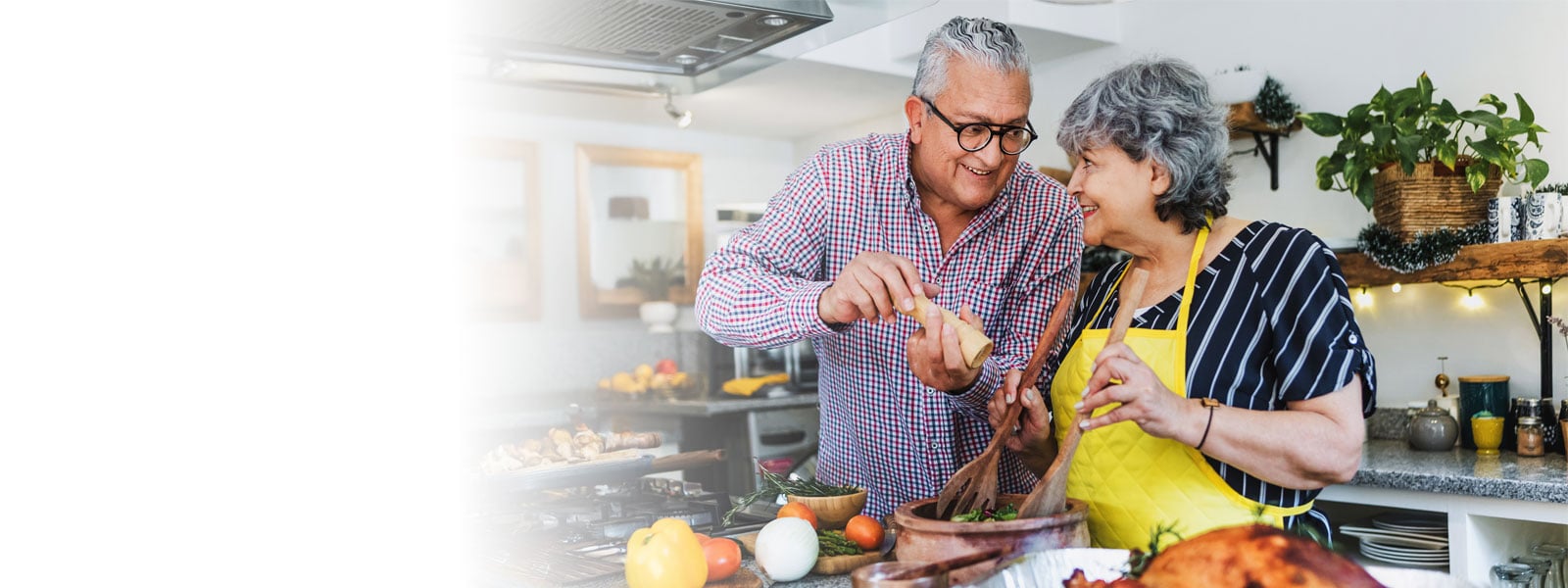 Hero image of an older couple cooking together.