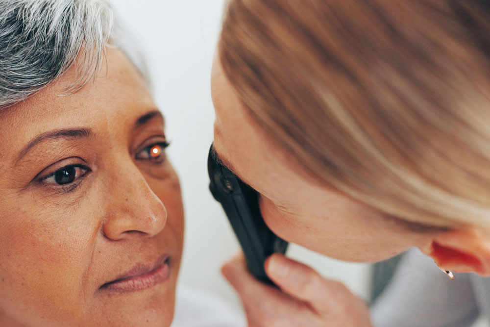 Eye doctor performing a cataract evaluation on an older patient during a comprehensive eye exam.